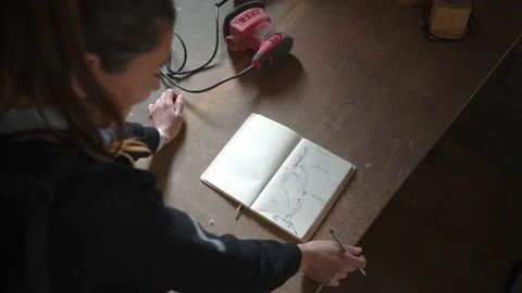 Craftswoman making sketch in notepad in workshop Stock Footage 167422880