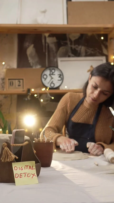 Craftswoman sits at her workspace table, gently molding and forming a clay .. Stock Footage 335881941