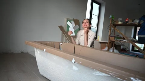Craftswoman smiling while assembling wooden boat model in workshop Stock Footage 323320920