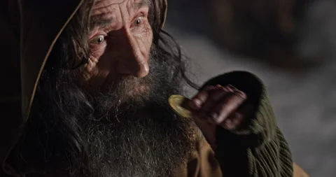 Crafty elderly man checking golden coin Vídeo Stock 168808193