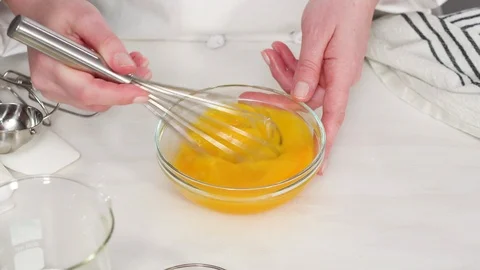 Craking white organic eggs into a small glass bowl. Stock Footage 120093859
