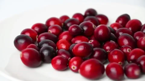 Cranberries settling onto white plate in close up sequence Stock Footage 331240671