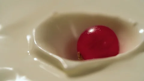 Cranberry falling in yogurt slow motion macro close-up Stock Footage 125380083
