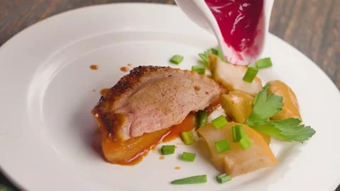 Cranberry sauce is poured over a piece of baked duck fillet Stock Footage 302215825