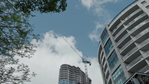 Crane active in building construction with workers on upper floors. Timelapse Stock Footage 253869711