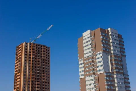 Crane and building construction site against blue sky Stock Photos