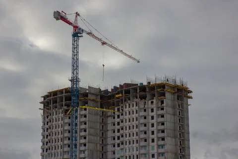 Crane and building construction site against blue sky. Stock Photos