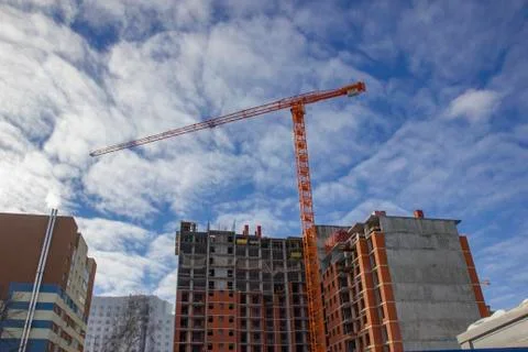 Crane and building construction site against blue sky. Stock Photos