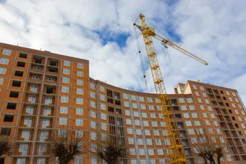 Crane and building construction site against blue sky Stock Photos