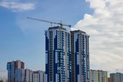 Crane and building construction site against blue sky Stock Photos
