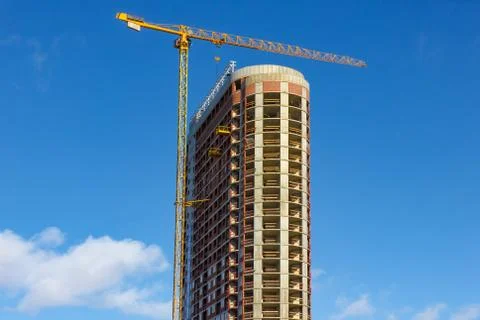 Crane and building construction site against blue sky Stock Photos
