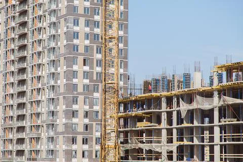 Crane and building under construction against blue sky Stock Photos