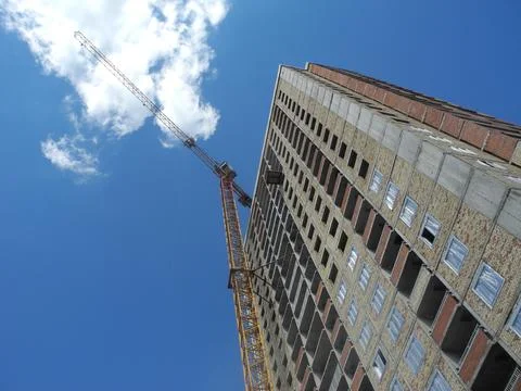 Crane and building under construction against blue sky Foto stock
