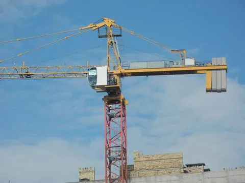 Crane and building under construction against blue sky Stock Photos