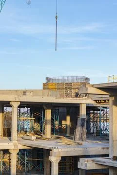 Crane and building under construction against blue sky on lake bank. Urban Stock Photos