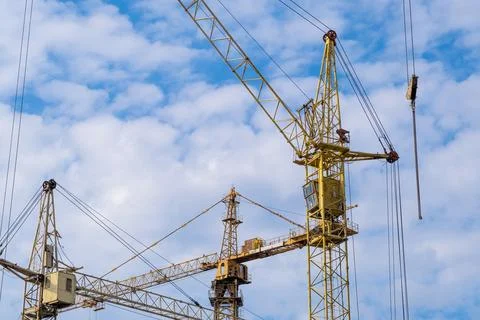 Crane and a building under construction against a blue sky background Stock Photos