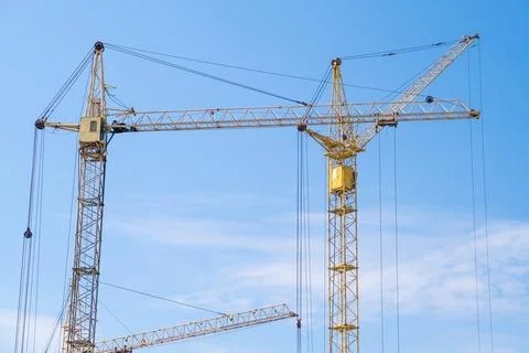 Crane and a building under construction against a blue sky background Stock Photos