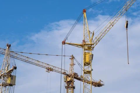 Crane and a building under construction against a blue sky background Stock Photos