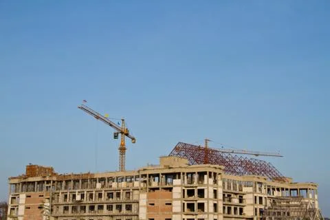 Crane and workers at construction site against blue sky. thailand Stock Photos