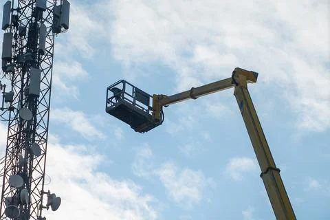 A crane with a basket in the air Stock Photos