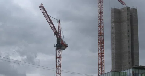 Crane boom arm rotates slowly next to tower block building skyscraper Stock Footage 340412228
