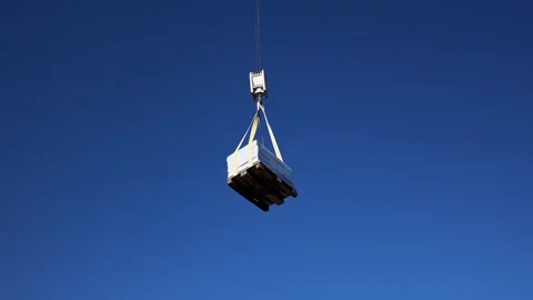 Crane with cargo loading unloading on the background of the sky Stock Footage 256958841