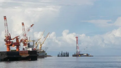 Crane on the coast is busy working Stockbeeldmateriaal 153744954