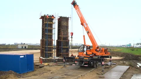 A crane at the construction site of the road. Workers on the road construction Stock Footage 95182777
