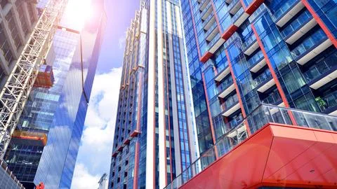 Crane on the construction site in a site surrounded by the high buildings. Stock Photos