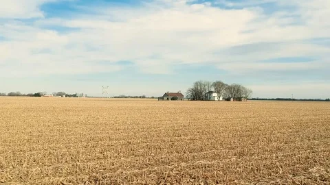 Crane down reverse tracking shot of farmhouse in middle of cornfield Stock Footage 100416562