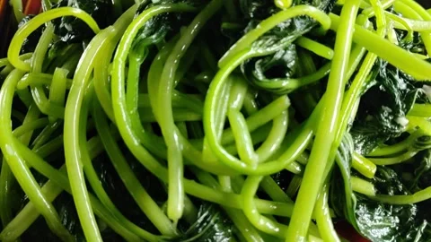 Crane-Down Shot of Stir-Fried Sweet Potato Leaves, Natural Light 库存影片 334225018