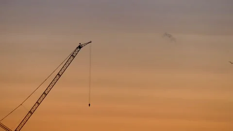 Crane with flashing light at sunrise - flying seagulls - orange sky - real time Stock Footage 142019697