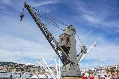 A crane on the floating dock in the harbor .Plenty of cargo ships needs oil and Stock Photos