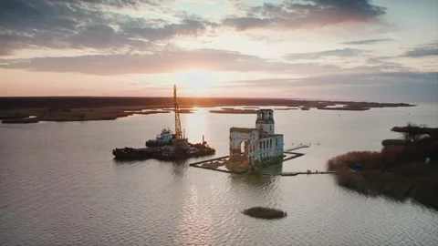 A crane on a floating platform unloads sand to strengthen the shore around an Stock Footage 218404298