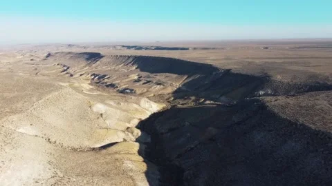 Crane flying over a wide mountain fault on a blue sky background Stock Footage 238912558