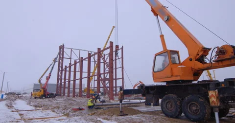 Crane with the help of a team of builders stores metal frames Stock Footage 161951700