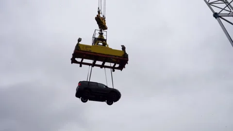 Crane hoists minivan over deck while rain streaks glisten Видео 320436610