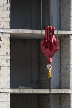 A crane hook and a building under construction Foto stock
