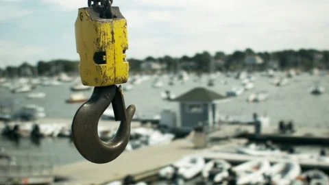 Crane Hook hanging against a soft focus marina bay in the background Stock Footage 116666302