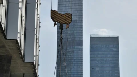 Crane hook lifting during skyscraper construction, symbolizing urban development Stock Footage 340504571