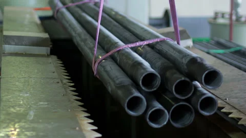 Crane hook lifting steel pipe bundle from band saw. Metal cutting plant shop. Video stock 345613093