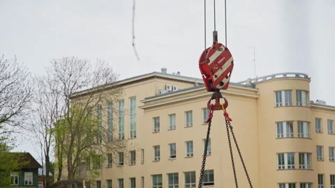 Crane hook moving near existing school building during new school construction Stock Footage 338355860