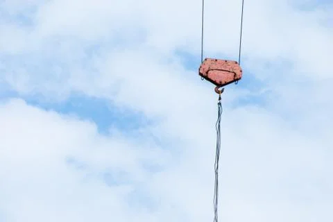 Crane hook with rope on blue cloudy sky Stock Photos