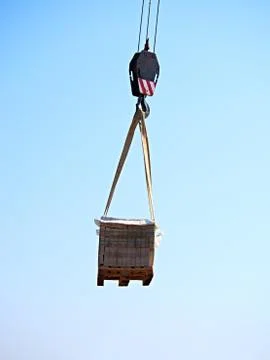 Crane Hook with Stacked white bricks on a wooden Pallet, clear blue sky in .. Foto stock