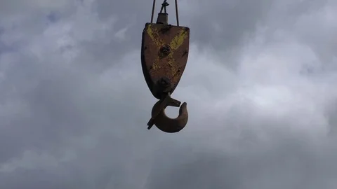Crane hook swinging against cloudy sky Видео 70411451
