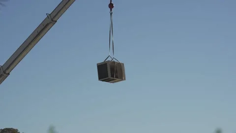 A crane lifting an air conditioner unit off of a roof Vídeos de archivo 145080457
