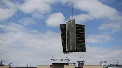 Crane lifting concrete formwork panels over building Vídeos de archivo 314234394