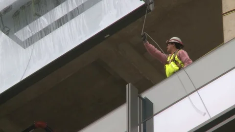 Crane Lifting Glass to be Installed into tall building Stock Footage 127530544