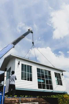 Crane lifting a knock down private house. Stock Photos