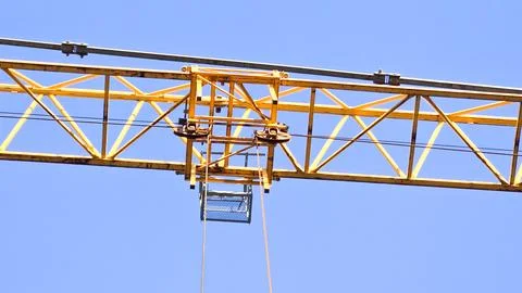 A crane is lifting a large object with a blue container on top Stock Photos